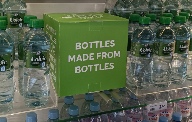 Bottles of water displayed along sign "bottles made from bottles"
